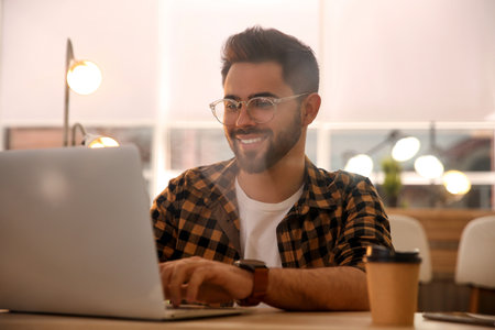 Man working with laptop at table in cafeの写真素材