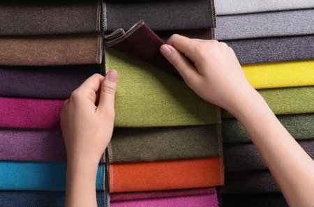 Woman choosing among colorful fabric samples, closeupの写真素材