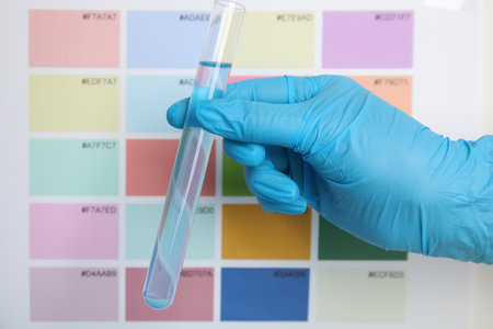 Doctor holding test tube with liquid near sample chart, closeupの写真素材