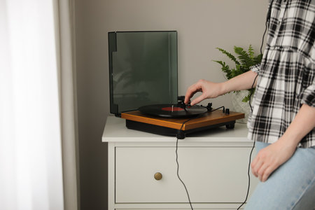 Young woman using turntable at home, closeupの写真素材