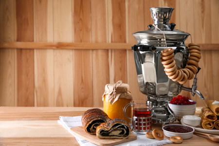 Traditional Russian samovar and treats on wooden table. Space for textの写真素材