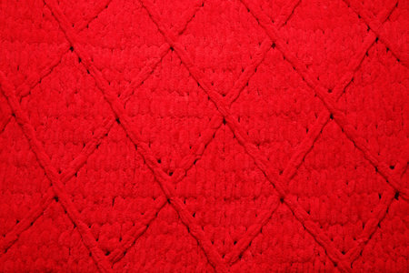 Red woolen fabric with geometrical pattern as background, top viewの写真素材