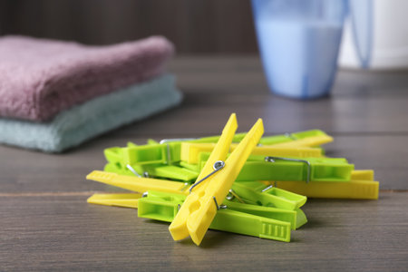 Pile of colorful plastic clothes pins on wooden tableの写真素材