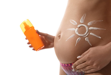 Pregnant woman with sun protection cream on white background, closeupの写真素材