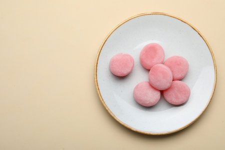 Plate with delicious mochi on beige background, top view. Space for textの写真素材