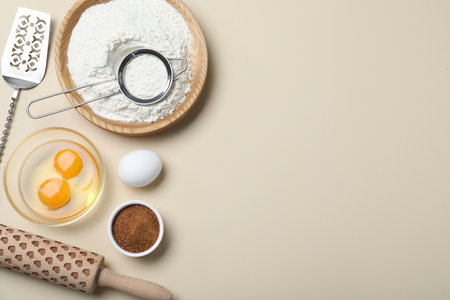 Cooking utensils and ingredients on beige background, flat lay. Space for textの写真素材