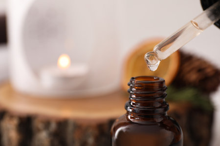 Dripping of coniferous essential oil into bottle, closeup. Space for textの写真素材