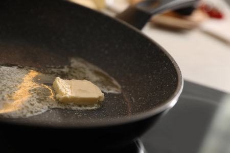 Frying pan with melted butter on stove, closeupの写真素材