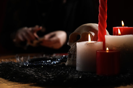 Soothsayer at table indoors, focus on skull and candlesの写真素材