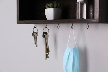 Wooden hanger for keys with different stuff on light gray wallの写真素材