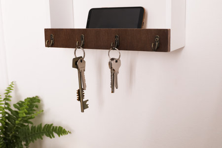 Wooden hanger for keys on white wallの写真素材