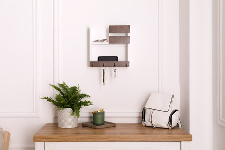 Wooden hanger for keys on white wall in hallwayの写真素材