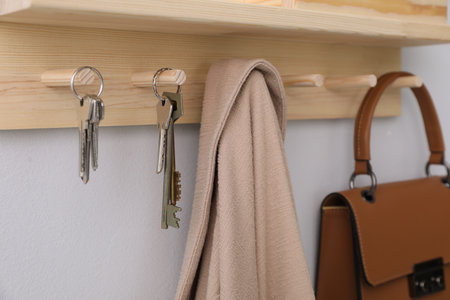 Wooden hanger for keys on light gray wall, closeupの写真素材