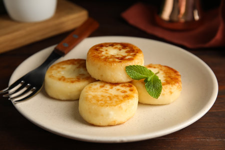 Delicious cottage cheese pancakes with mint on wooden tableの写真素材