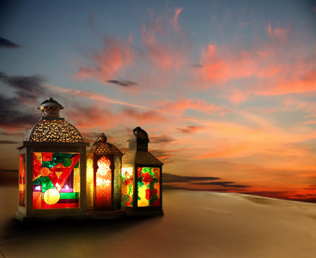 Beautiful Arabic lanterns on sand at sunset, space for textの写真素材