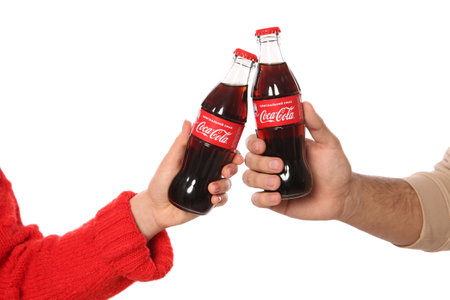 MYKOLAIV, UKRAINE - JANUARY 27, 2021: Couple holding bottles of Coca-Cola on white background, closeupのeditorial素材