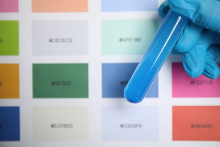Doctor holding test tube with liquid near sample chart, closeupの写真素材