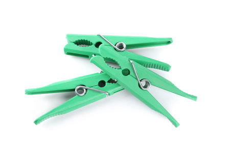 Bright green plastic clothes pins on white backgroundの写真素材