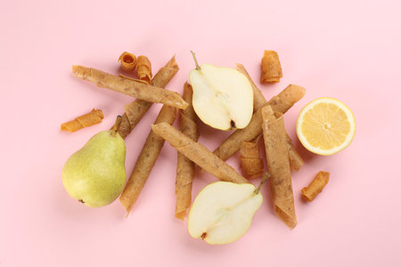 Delicious fruit leather rolls, pears and lemon on pink background, flat layの写真素材