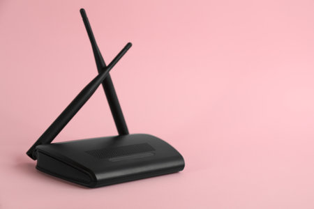 Modern WiFi router on light pink background. Space for textの写真素材