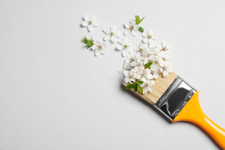 Paint brush and beautiful flowers on white background, flat lay. Space for textの写真素材