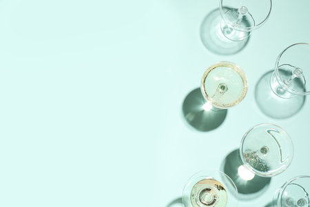 Set of empty glasses on light blue background, flat lay. Space for textの写真素材