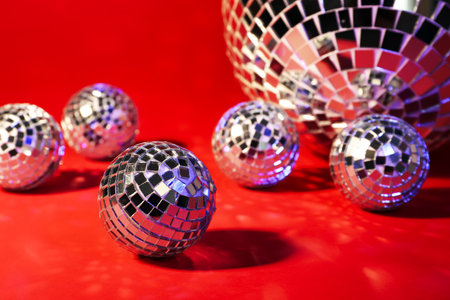 Beautiful shiny disco balls on red background, closeupの写真素材