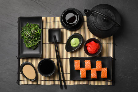 Tasty sushi rolls served on black table, flat layの写真素材