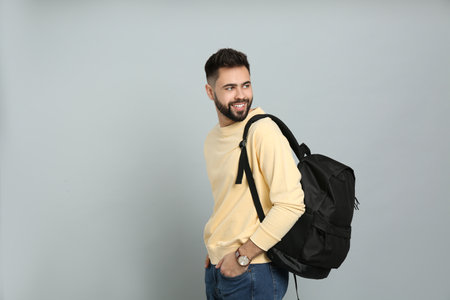 Young man with stylish backpack on light gray background. Space for textの写真素材