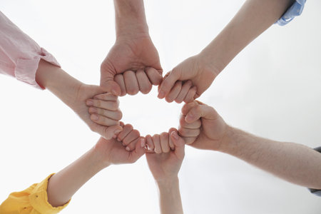 People holding fists together indoors, bottom viewの写真素材