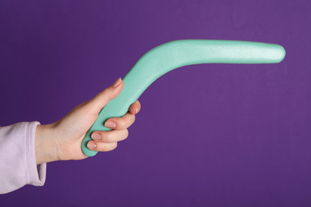 Woman holding boomerang on purple background, closeupの写真素材