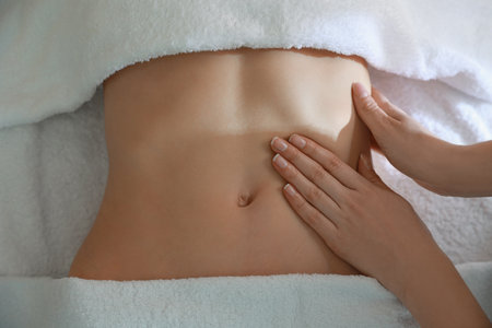 Woman professional receiving belly massage, closeup viewの写真素材