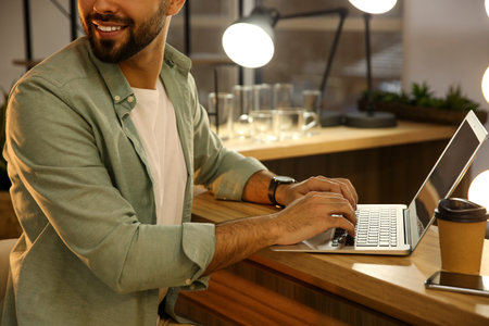 Man working with laptop at table in cafe, closeupの写真素材