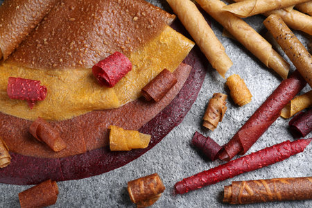 Delicious fruit leather rolls on gray table, flat layの写真素材
