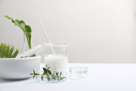 Organic cosmetic product, natural ingredients and laboratory glassware on white table, space for textの写真素材