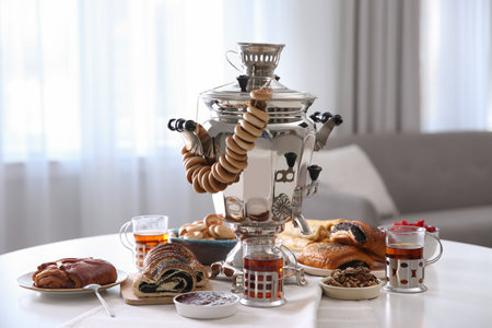 Traditional Russian samovar with treats on white table at homeの写真素材