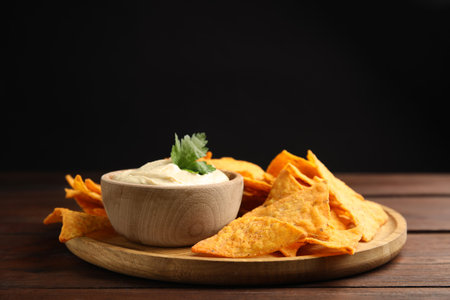 Delicious hummus with nachos on wooden tableの写真素材