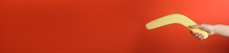 Woman holding boomerang on red background, closeupの写真素材