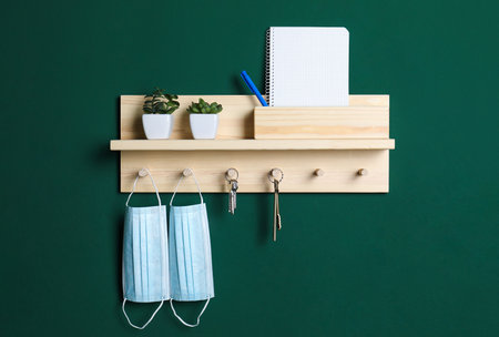 Wooden hanger for keys on green wallの写真素材