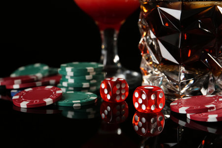 Casino chips, dice and alcohol drinks on dark background, closeupの写真素材