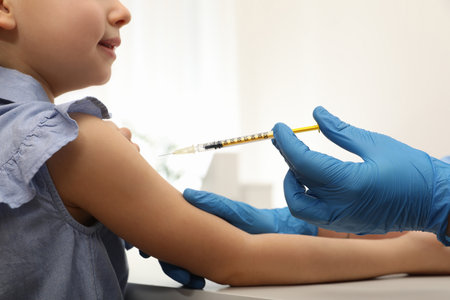 Doctor giving injection to little girl in hospital, closeup. Immunization conceptの写真素材