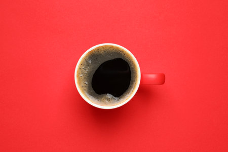Cup of aromatic coffee on red background, top viewの写真素材