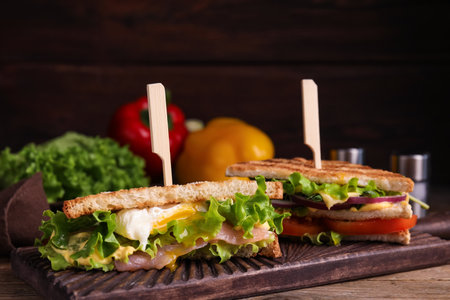 Wooden board with tasty sandwiches on tableの写真素材