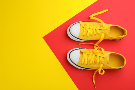 Pair of trendy sneakers on color background, flat lay. Space for textの写真素材