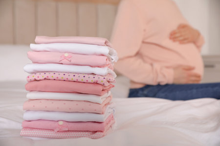 Pregnant woman in bedroom, focus on girl's clothesの写真素材