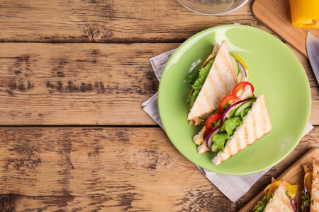 Green plate with tasty sandwiches on wooden table, flat lay. Space for textの写真素材