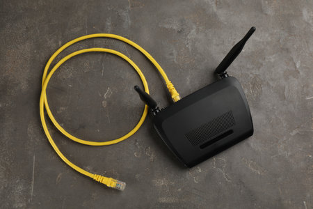 Modern Wi-Fi router on gray background, top view