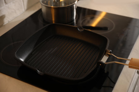 Frying pan on modern cooktop in kitchenの写真素材