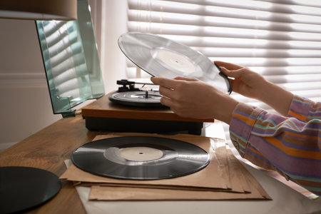 Young woman using turntable at home, closeupの写真素材