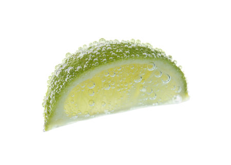 Fresh lime slice in sparkling water on white backgroundの写真素材